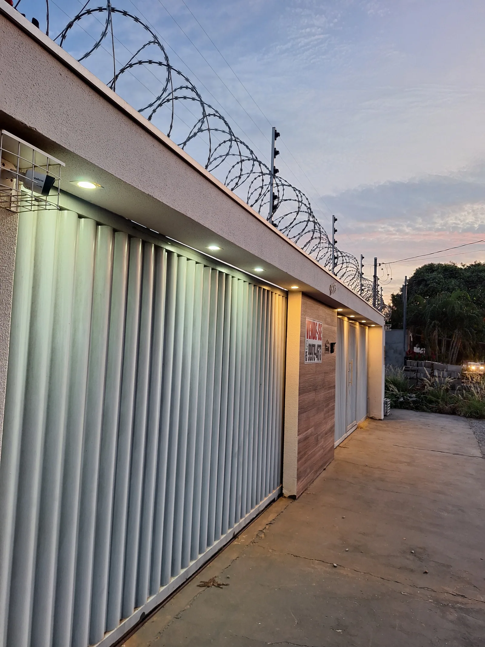 Fachada com portão, iluminação e segurança (concertina, cerca e câmera)